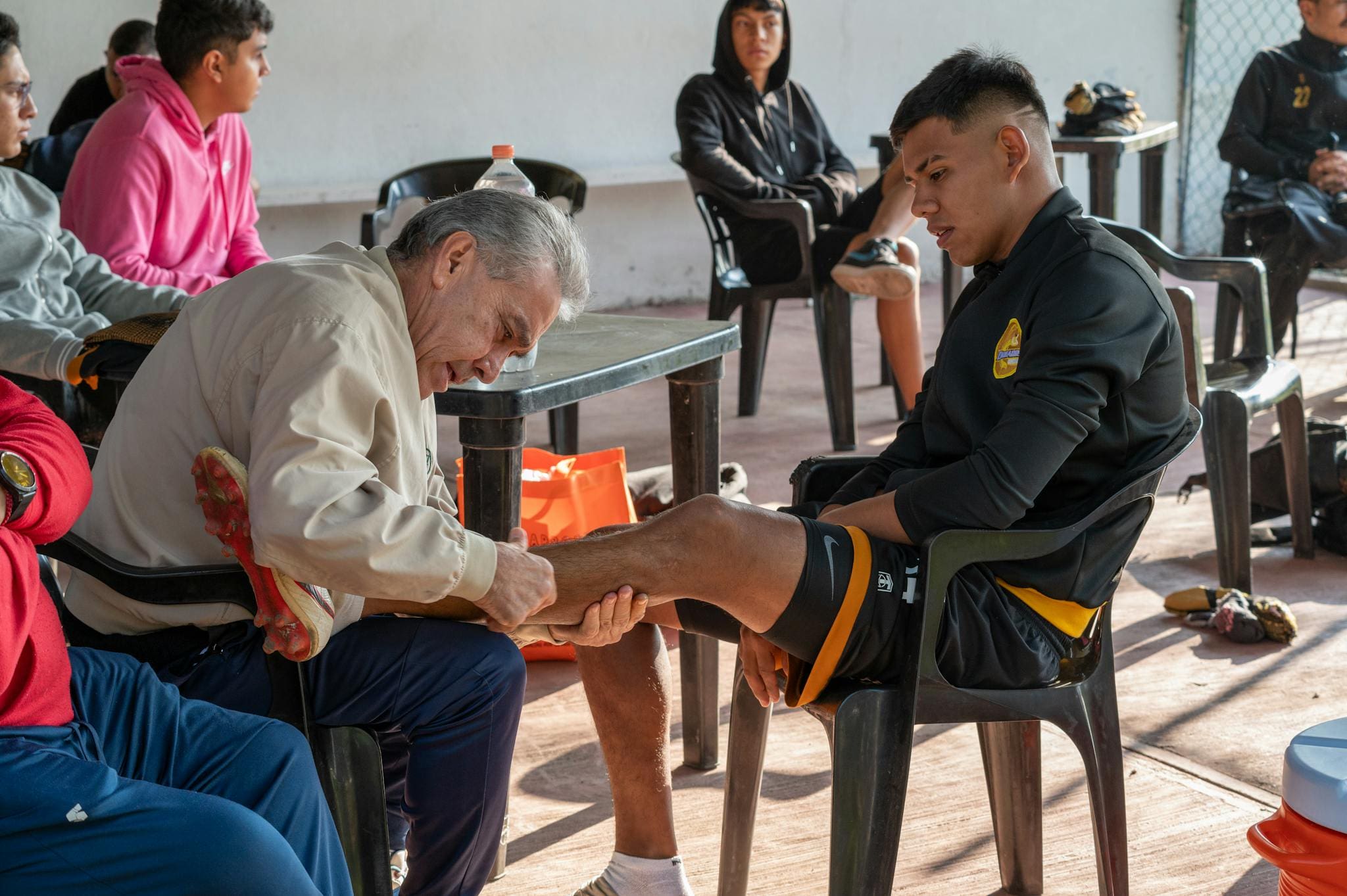 A coach attends to a soccer player's injury, offering support and care during training.